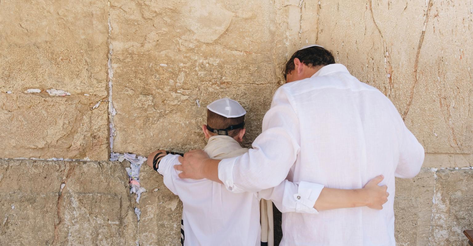a father and son prayer together at the kotel