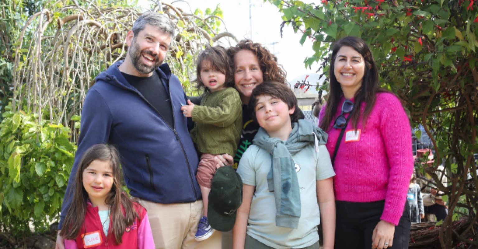 one man, two women, and three children smile at the camera
