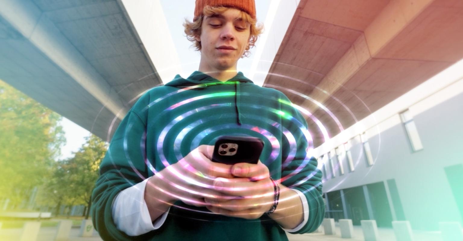 A male teenager looking down at his phone