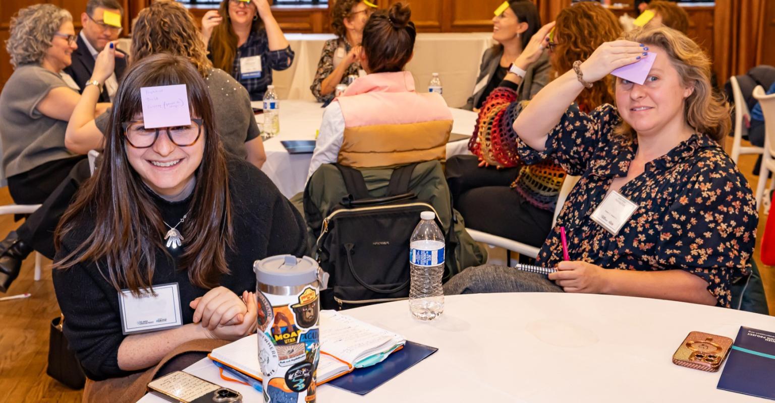 educators at a table with sticky notes on their foreheads