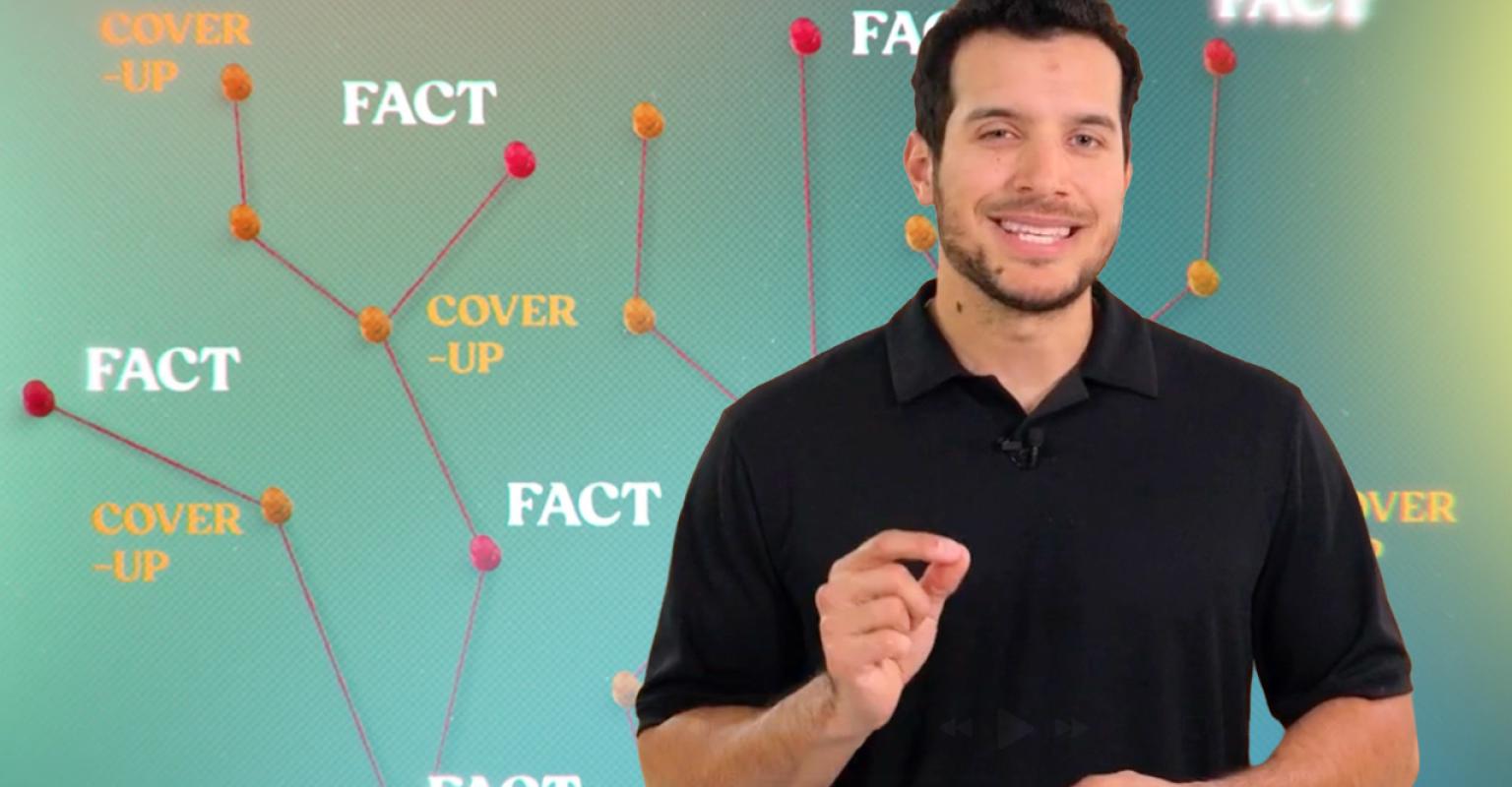 Man standing in front of web of words that say "fact" and "cover-up"