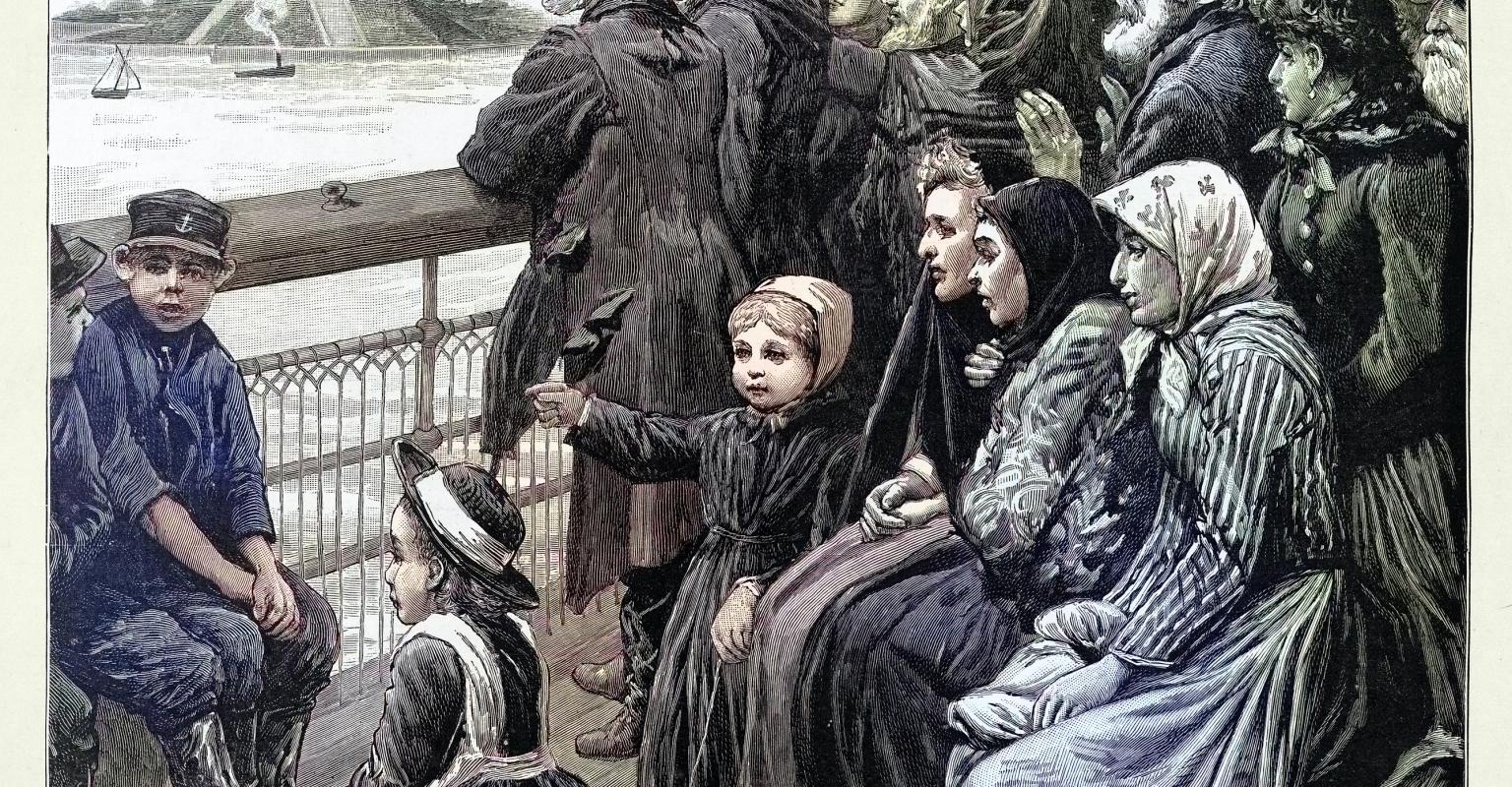 Immigrants crowded on a ship deck viewing the Statue of Liberty as they arrive in New York Harbor.
