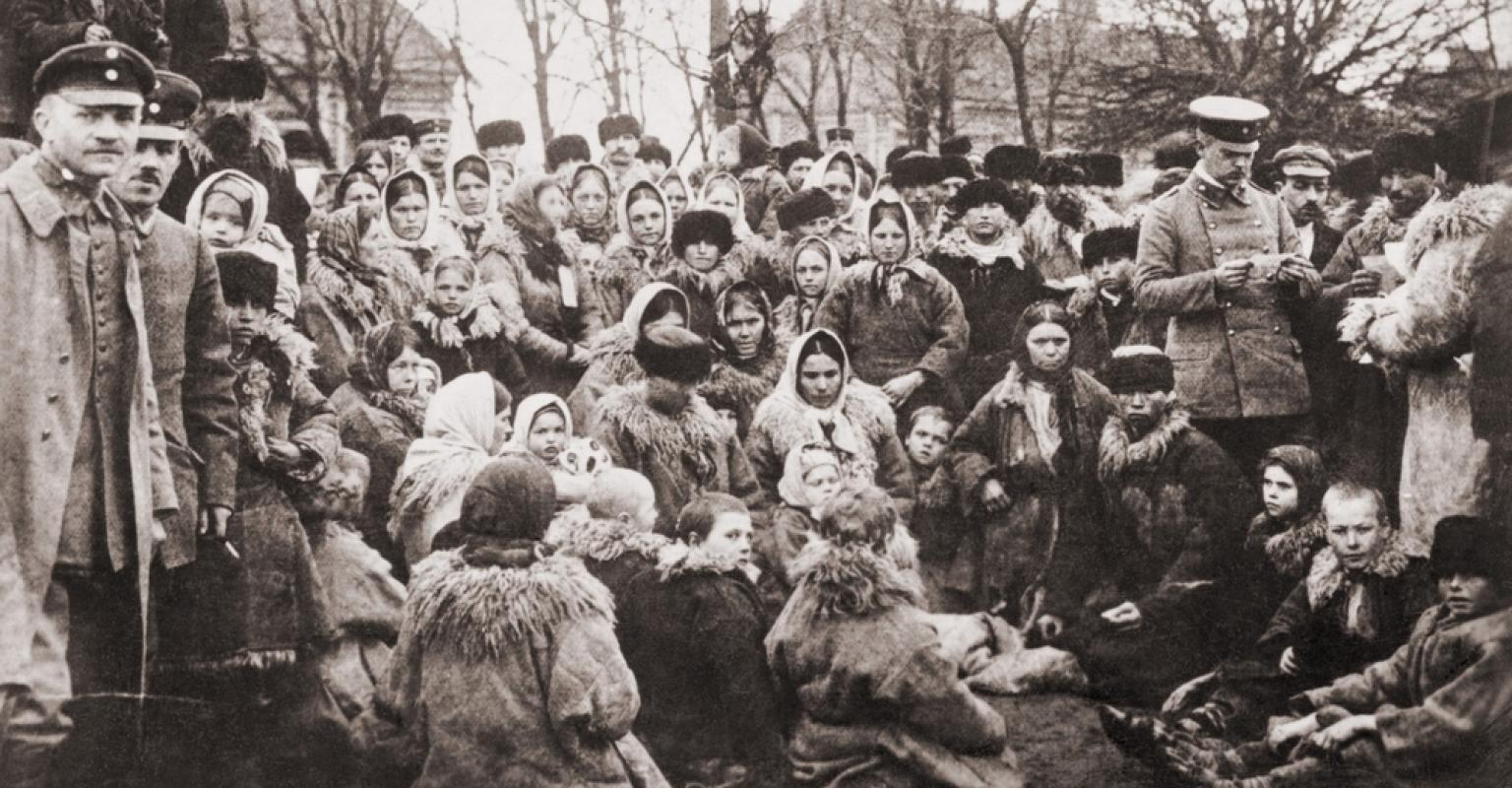 Crowd of Eastern European emigrants, possibly Jewish, with three Russian officials, who are reviewing their travel papers. ca. 1912.