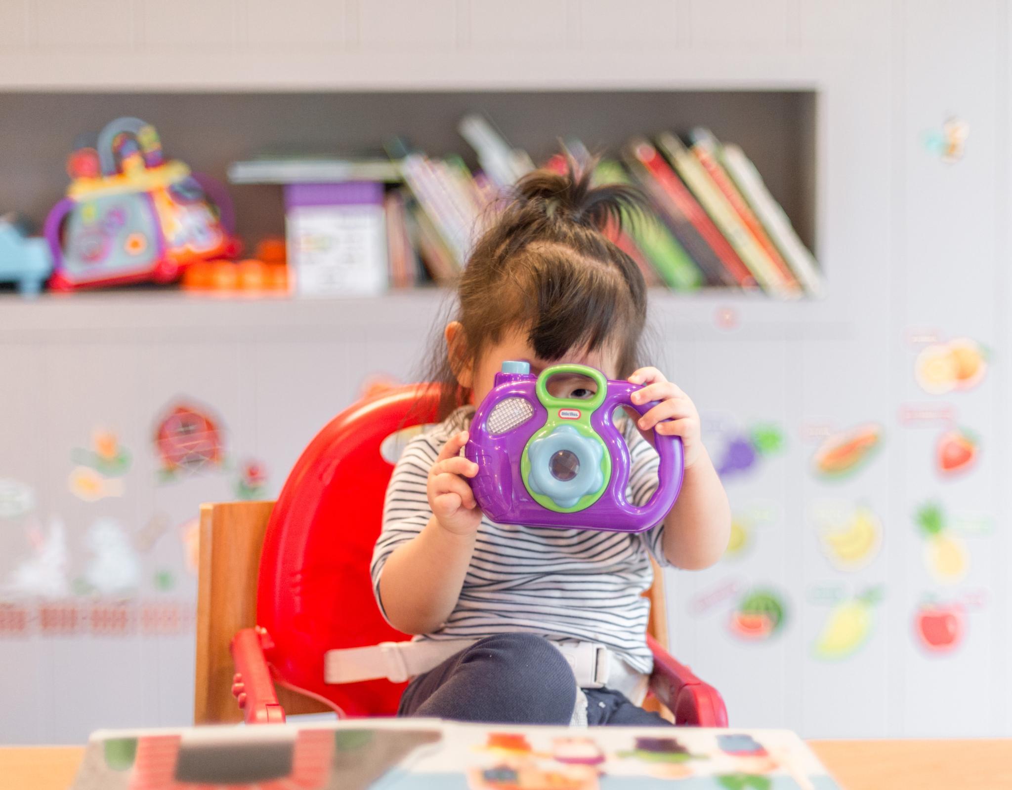 Preschool child looking through toy camera