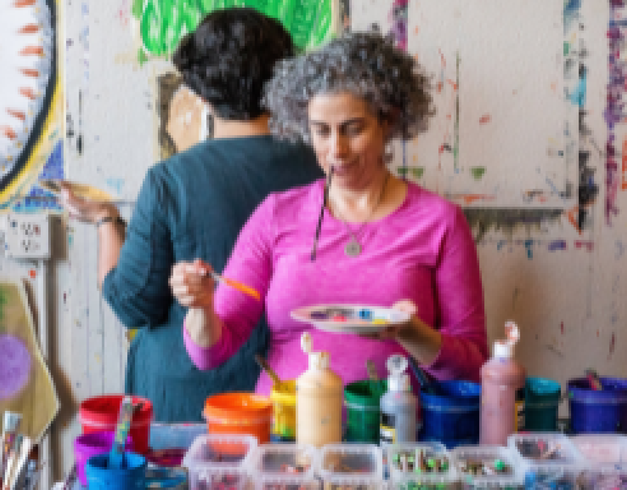 A woman uses a paintbrush