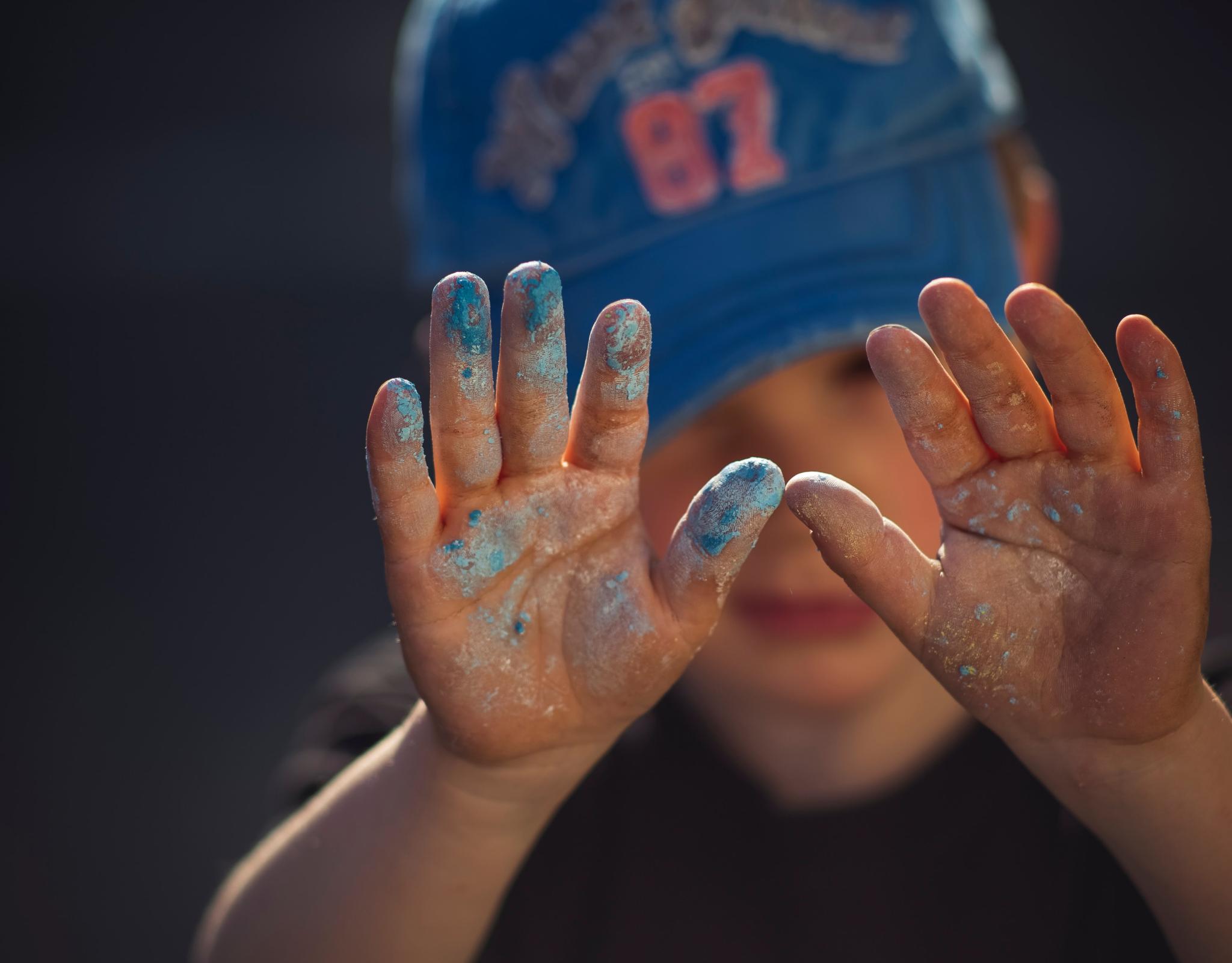 Child in baseball hat with raised hands