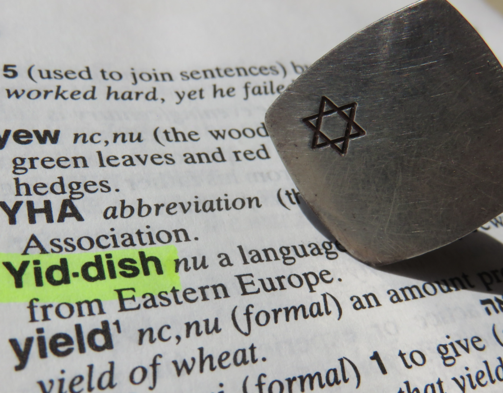 Yiddish highlighted in the dictionary with a paper weight that has the Star of David on it