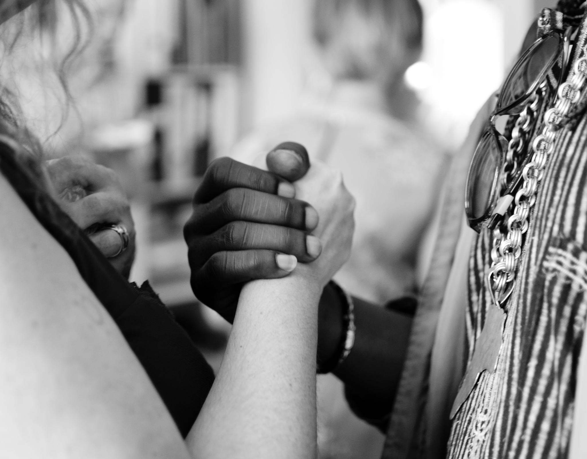 Two people holding hands in solidarity