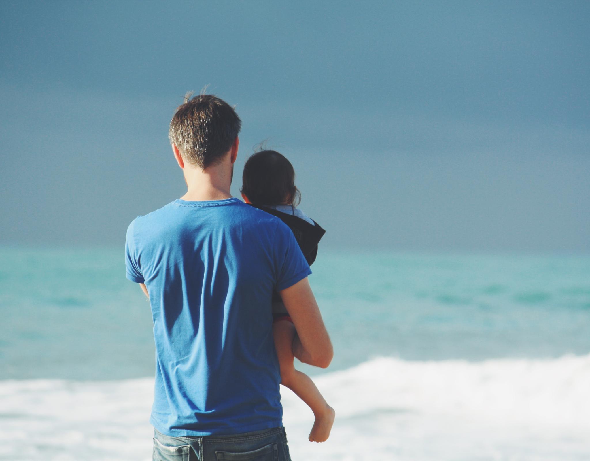 Parents and small child looking out at sea