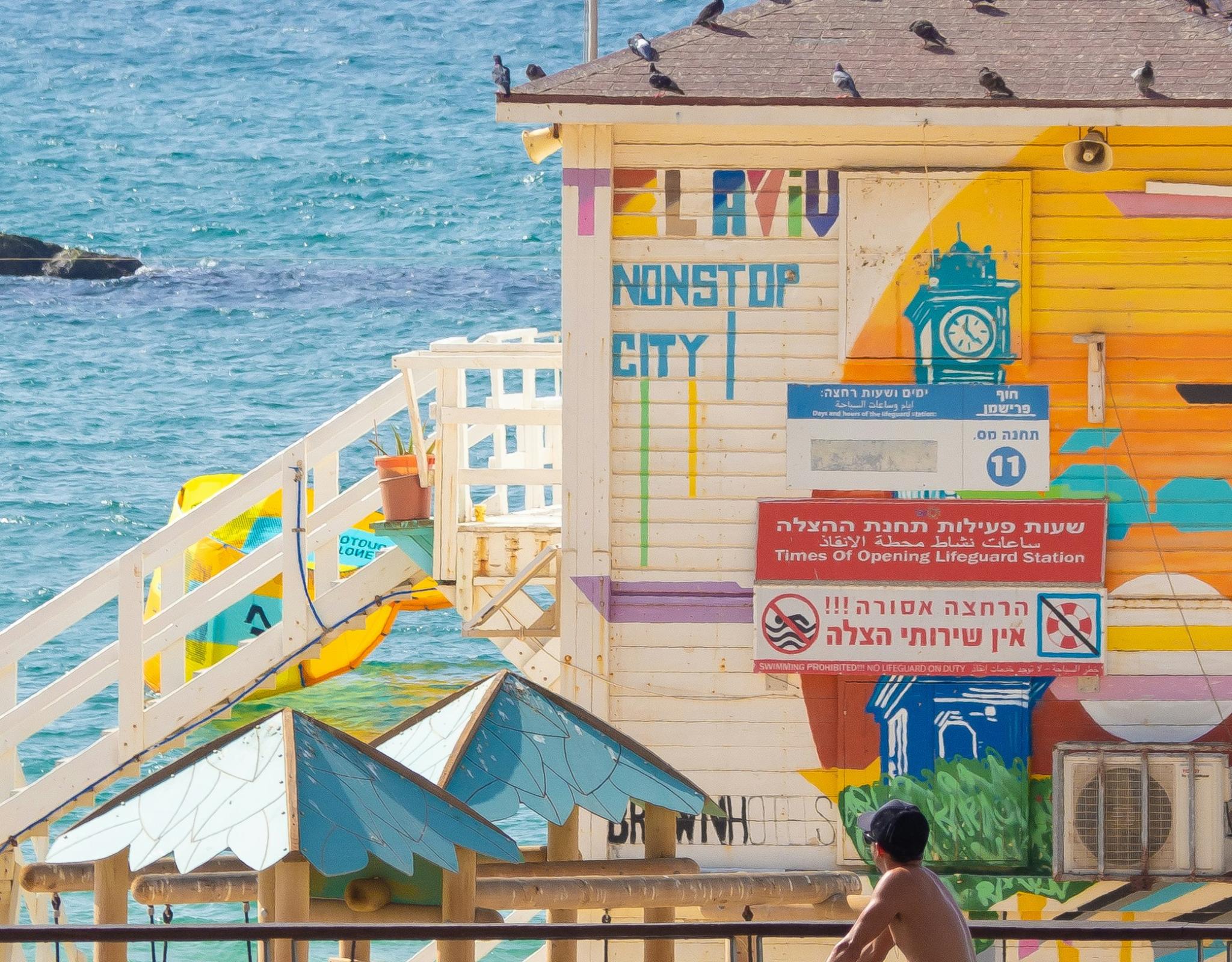 A seaside building that says, Tel Aviv Nonstop City