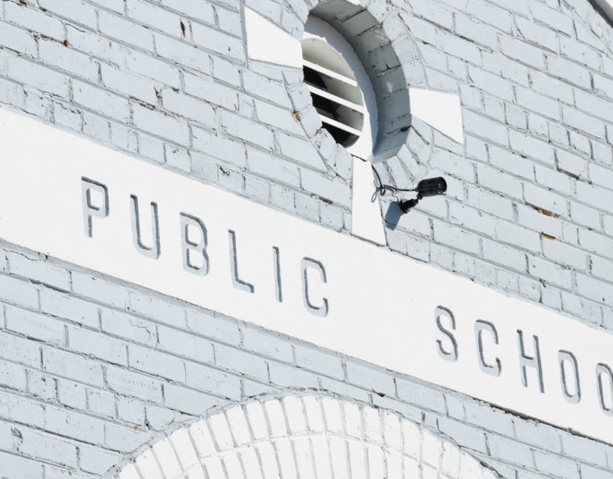 A gray building with the words Public School on a sign