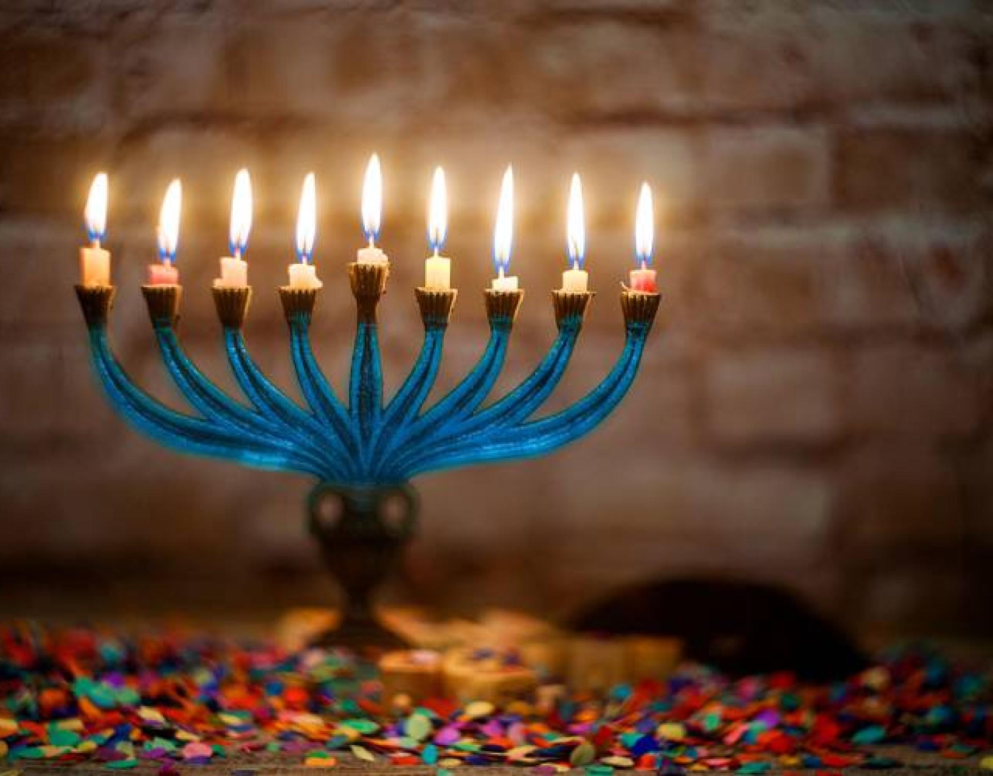 Menorah fully lit with confetti underneath