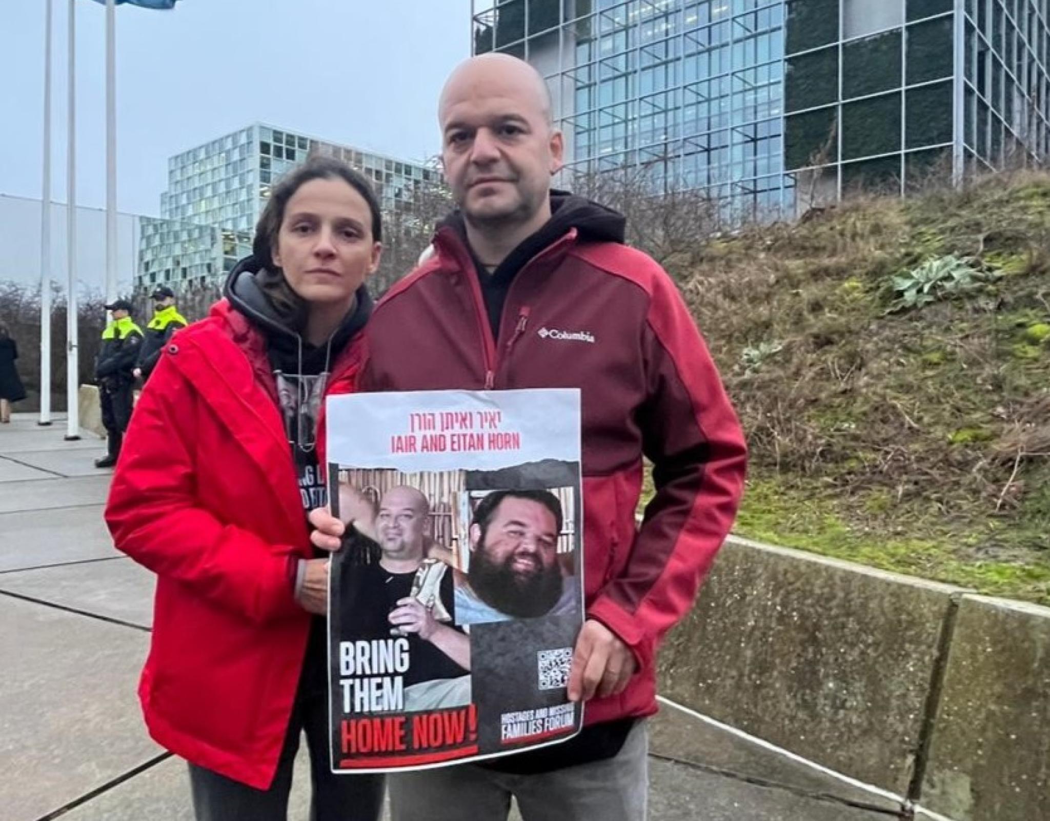 Dalia and her husband holding a hostage poster for her brothers-in-law in front of the UN building