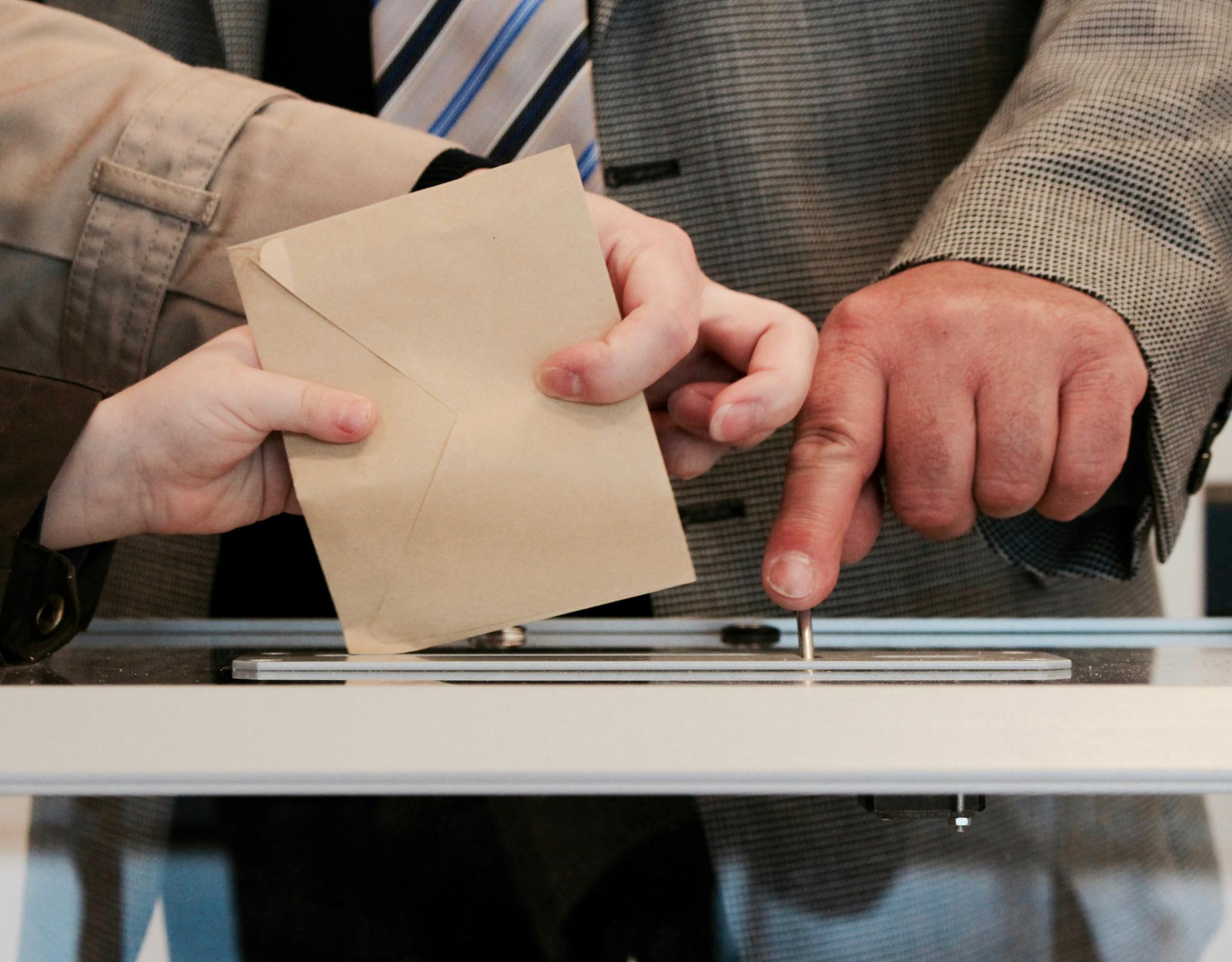 voting envelope being placed in box