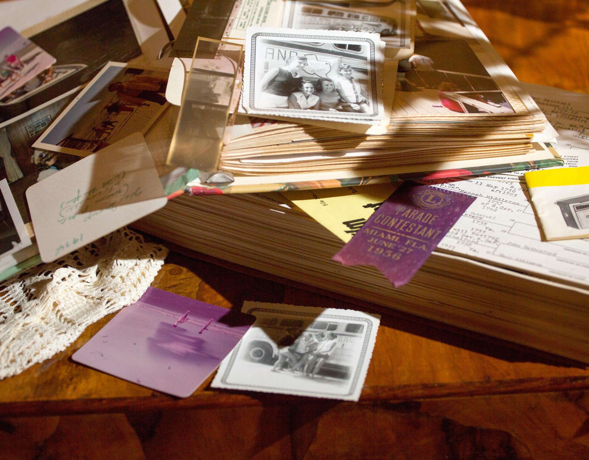 scrapbook, photographs, and other personal memorabilia sprawled on table