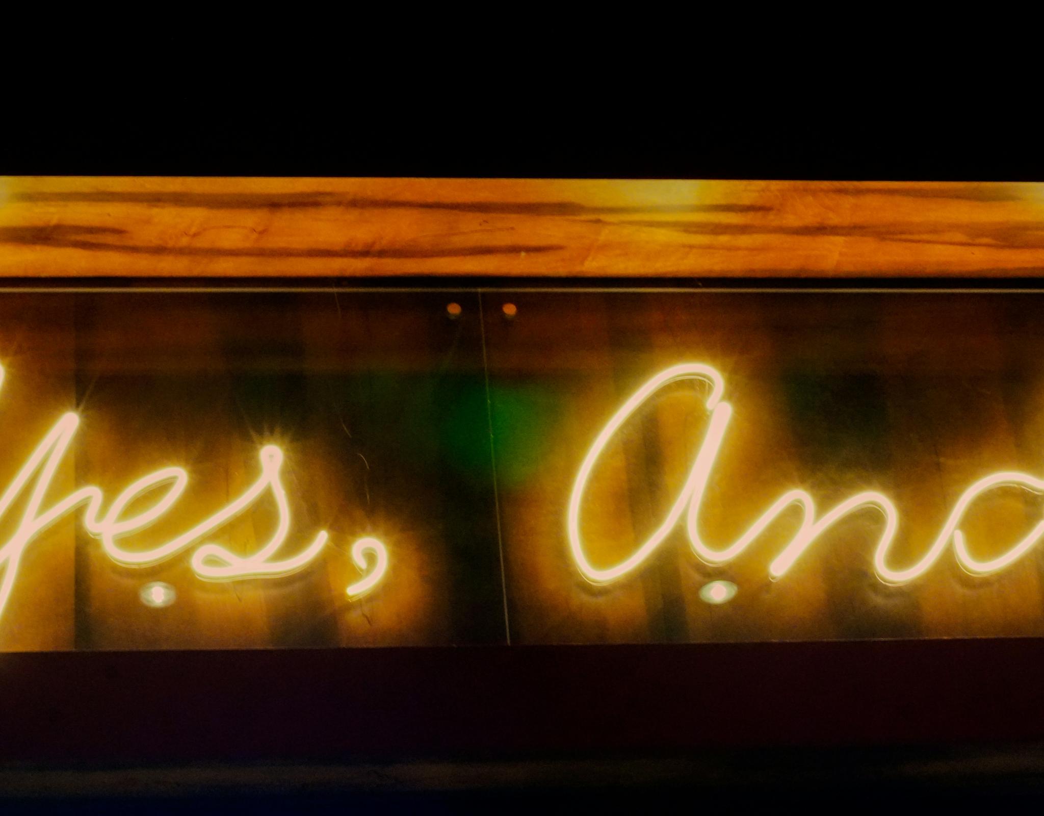Neon sign saying "yes, and"