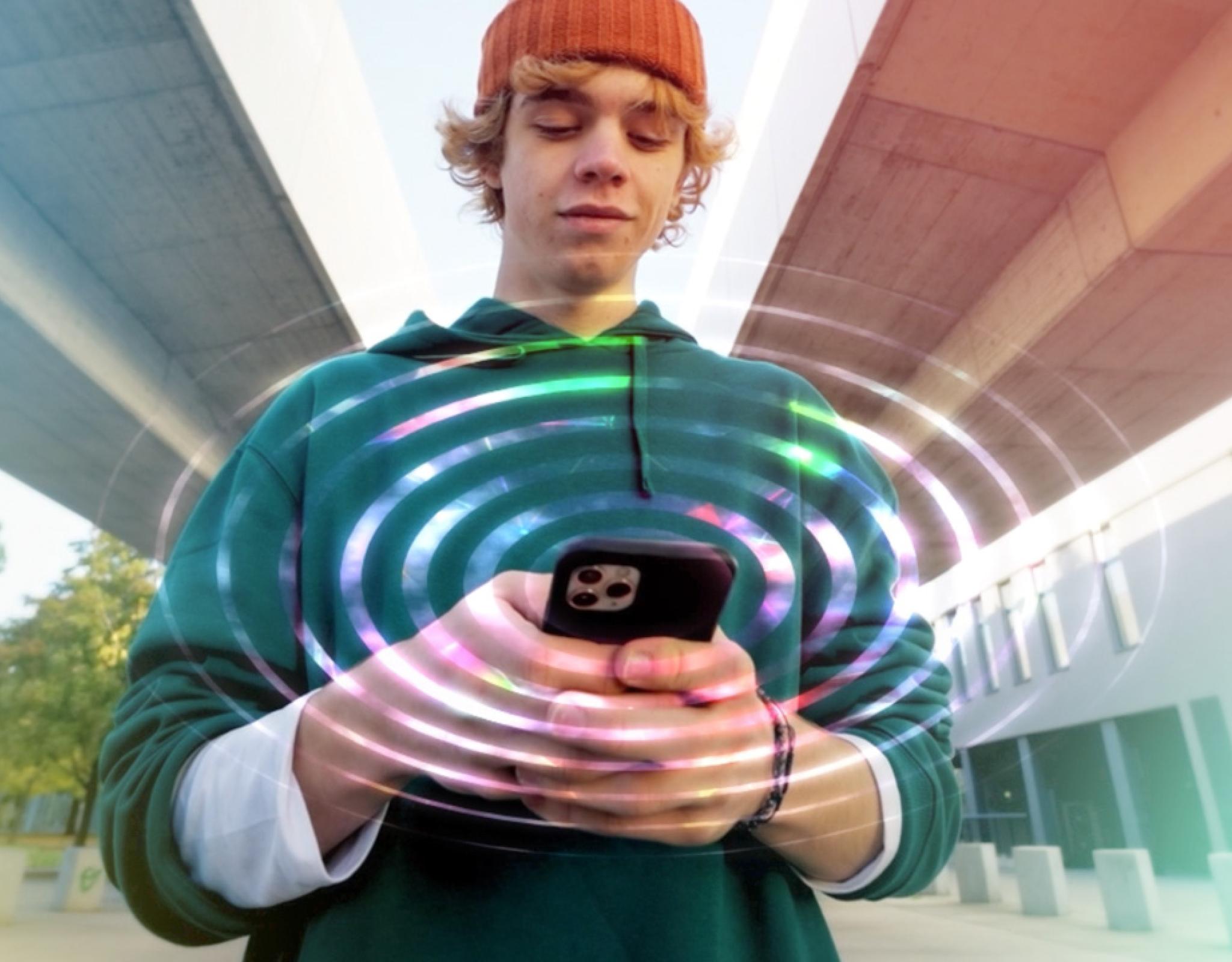 A male teenager looking down at his phone