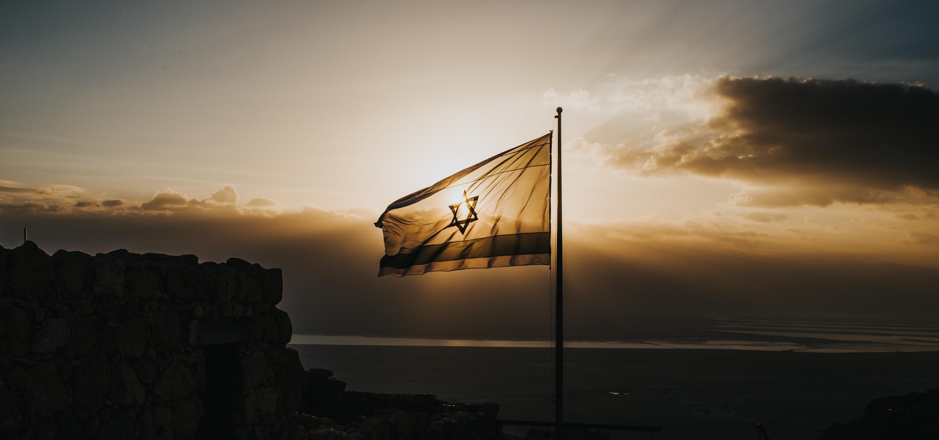 Israeli flag waving in sunset