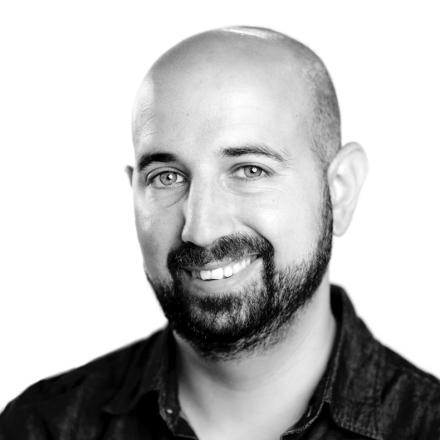 A black-and-white headshot of Yotam Wolk. 