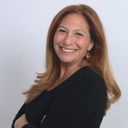 A headshot of Sarah in front of a white background. 