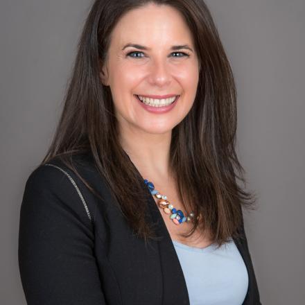 A headshot of Shuli Karkowsky in front of a grey background. 