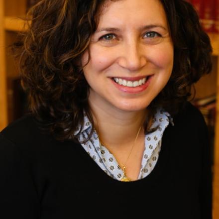 A headshot of Wendy Amsellem in front of a library shelf.