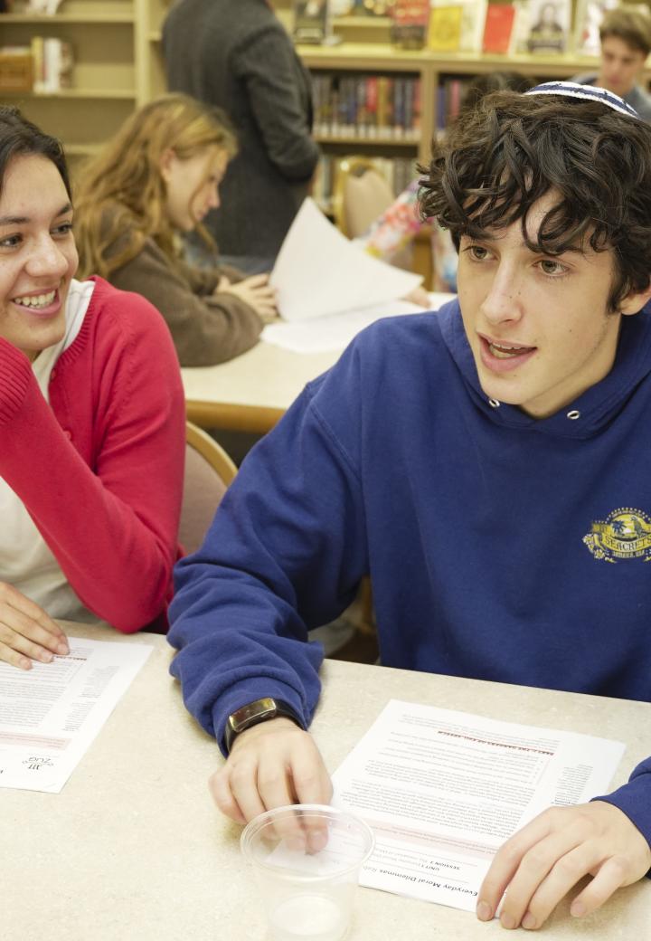 two learners at a table, talking with source sheets in front of them